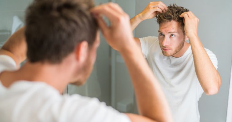 A man looking at his hair