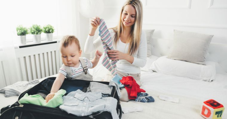 A mum with her baby packing a suitcase