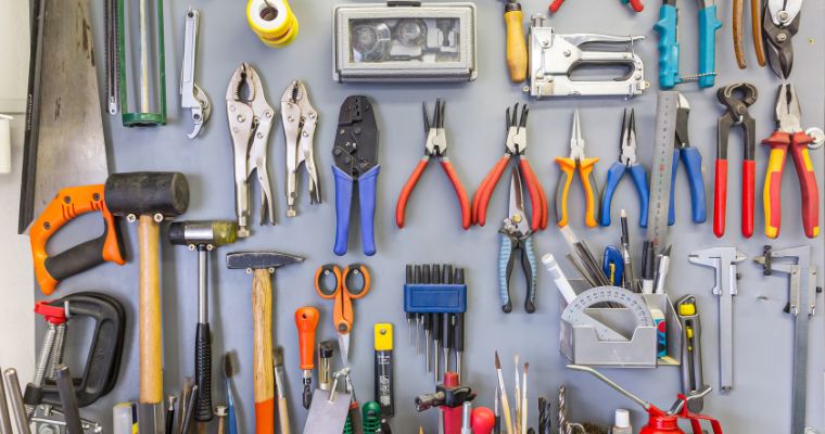 Set of different DIY tools hanging on a wall