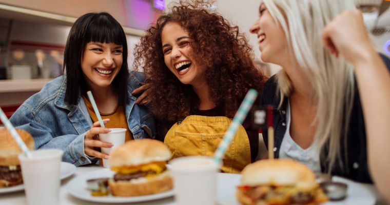 Young women eating burgers in a restaurant