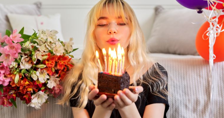 A girl blowing out candles on a slice of birthday cake