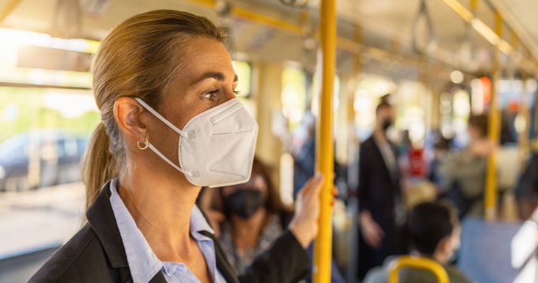 A woman wearing a mask on a bus